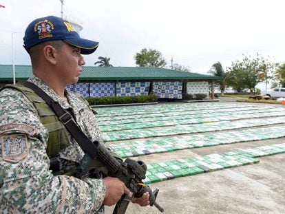 A member of the Colombian military stands next to a cocaine haul in the city of Turbo.