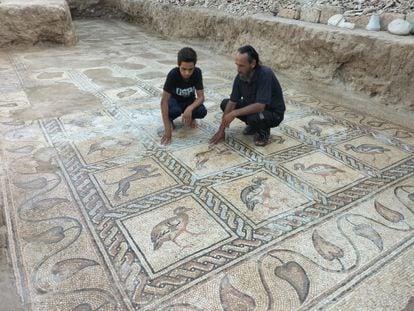 Salman al Nabahin and his son Ahmed, standing on the mosaic uncovered near their home in the Al Bureij refugee camp in Gaza; October 2022.