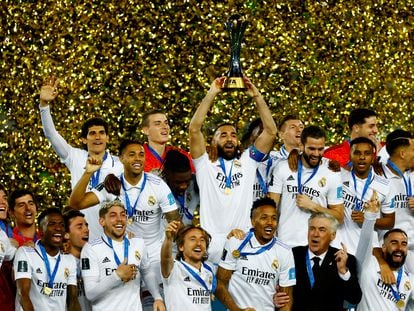 Real Madrid's Karim Benzema lifts the trophy with teammates and coach Carlo Ancelotti after winning the 2023 FIFA Club World Cup final.