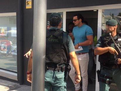 The Civil Guard escorts the owner of the real estate agency after his arrest.