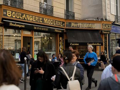People walk past the "Modern bakery", Place de d'Estrapade, in Paris