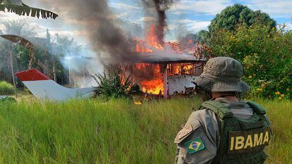 An Ibama agent observes the burning of a poaching miners' plane during an operation on Yanomami land, in February 2023.