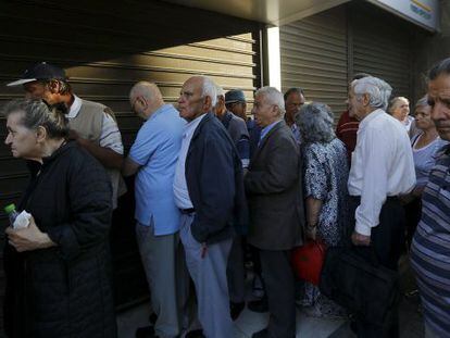 Dozens of Greek pensioners standing in line in front of a bank in Athens to collect their checks.