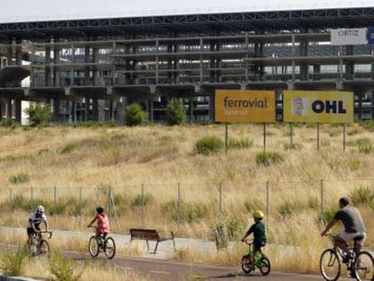 Cyclists make their way past the unfinished aquatic center, which was set to be a key venue had Madrid's Olympic bid prospered.