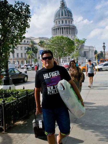 A man wearing an imported US designer t-shirt walks in Havana.