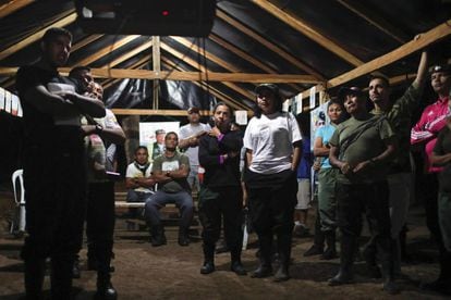 FARC guerrillas watch TV at a camp.