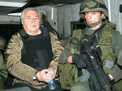Police officers escort the drug kingpin Gilberto Rodr&iacute;guez Orejuela in 2004.