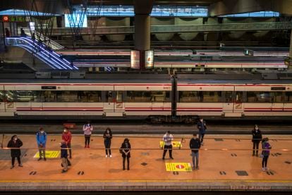 Passengers wait at a platform of Atocha train station in Madrid.