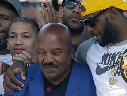 Former Cleveland Browns player Jim Brown, left, gets a hug from LeBron James, who holds the Larry O'Brien NBA championship trophy during a rally June 22, 2016, in Cleveland.