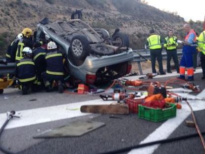 Firefighters extract bodies from a car following an accident in Granada.