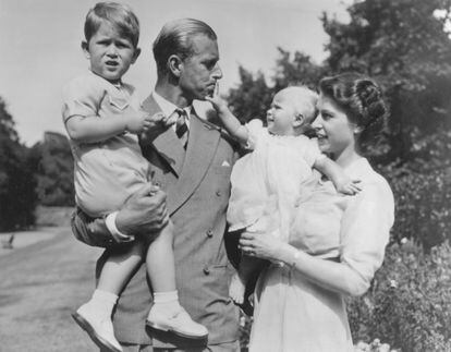 Prince Charles, aged two, in his father, the Duke of Edinburgh’s arms. His mother, then Princess Elizabeth, holds Princess Anne as they walk through the grounds of Clarence House, London, Aug. 9, 1951.

