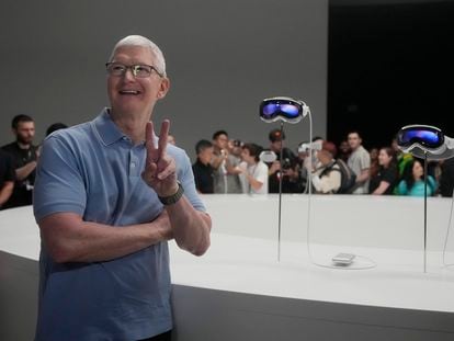 Apple CEO Tim Cook poses for photos in front of the company's new Apple Vision Pro headsets in a showroom on the Apple campus Monday, June 5, 2023, in Cupertino, Calif.