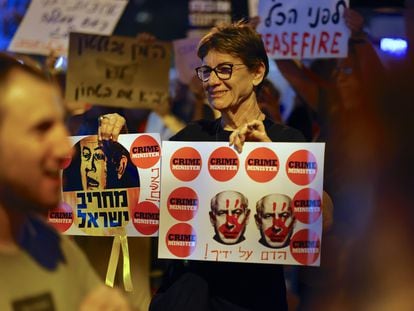 A woman holds a banner against Israeli Prime Minister Benjamin Netanyahu during a rally in Tel Aviv on October 28.