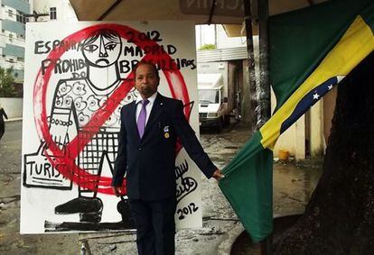 Menelaw Sete poses in front of one of the artworks he has produced in protest.