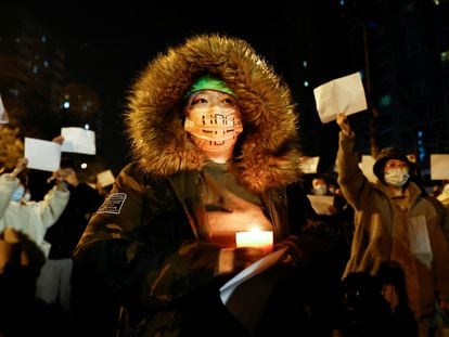 A person holds a candle during a protest in Beijing on November 27.