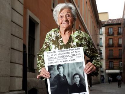 Ascensión Mendieta holds a poster with a photo of her parents. Her father is still buried in a mass grave.