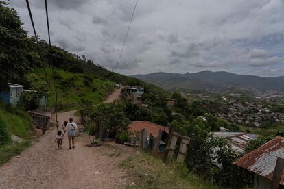 A woman and a girl walk through the Canaán neighborhood.