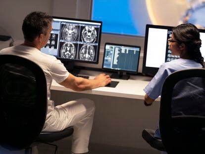 Two radiologists review a brain scan.