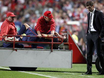 Suffering from a dislocated elbow, Carles Puyol is stretchered past Bar&ccedil;a coach Tito Vilanova in Tuesday&rsquo;s game.