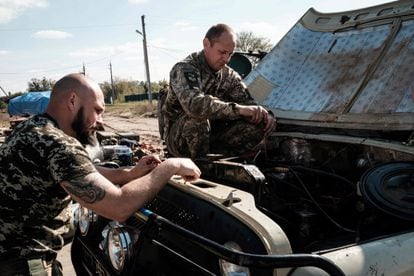 Ukrainian soldiers inspect an abandoned Russian tank.