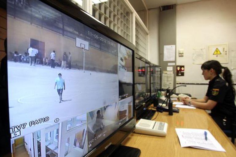 A police officer monitors detainees at a Madrid migrant detention center.
