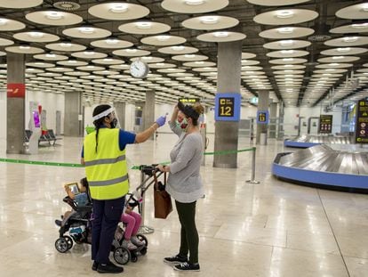 A traveler arriving in Madrid's Barajas Airport last summer has her temperature checked.