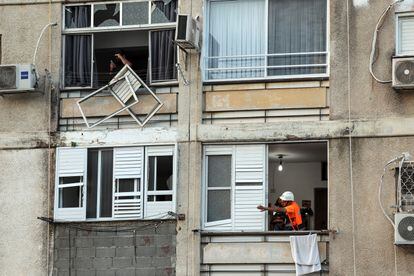 An Israeli emergency service official on Monday next to a window damaged by a Hamas attack in Ashkelon. 