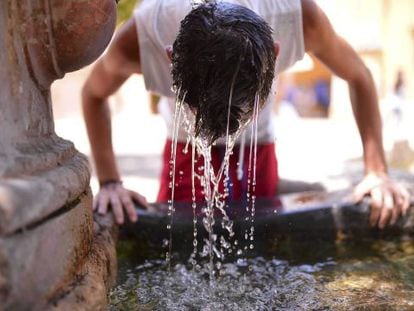 A young man tries to stay cool at a fountain inside the Mosque-Cathedral of Córdoba.