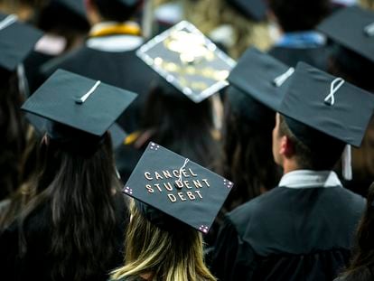 The cap of a University of Iowa graduates candidate is decorated with writing reading "Cancel student debt" during a commencement ceremony on May 14, 2022, at Carver-Hawkeye Arena in Iowa City, Iowa.