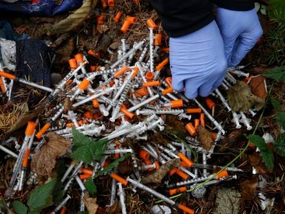 A volunteer cleans syringes found near a homeless encampment in the city of Everett, Washington State.