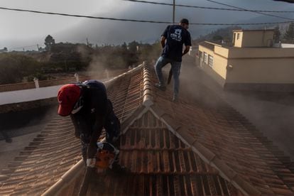 Federico and a colleague clear the ash from a house in El Paso.