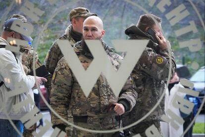 Visitors wearing military camouflage stand at the entrance of the 'PMC Wagner Centre', which is associated with businessman and founder of the Wagner private military group Yevgeny Prigozhin, during the official opening of the office block during National Unity Day, in St. Petersburg, Russia, Friday, Nov. 4, 2022.