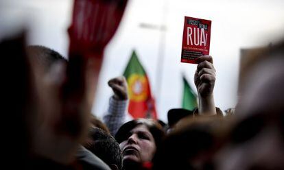 A woman brandishes a leaflet saying &quot;Passos Troika Out!&quot; during Saturday&#039;s march in Lisbon.