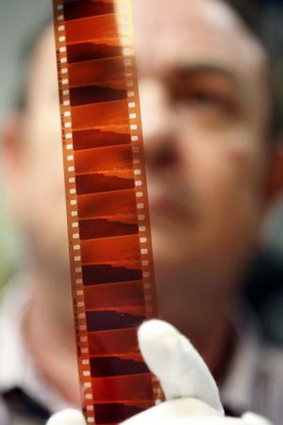 A Madrid Film employee checks a piece of celluloid.