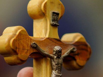 A woman holds a crucifix