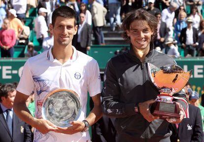 Rafael Nadal (l) and Novak Djokovic pose with their trophies.