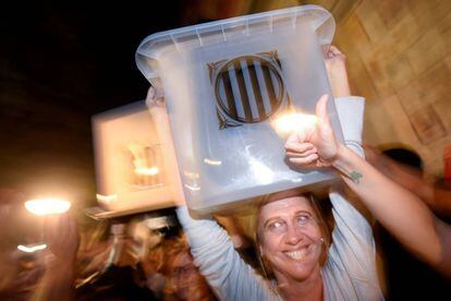 A poll worker holds up a ballot box after voting closes in Barcelona.