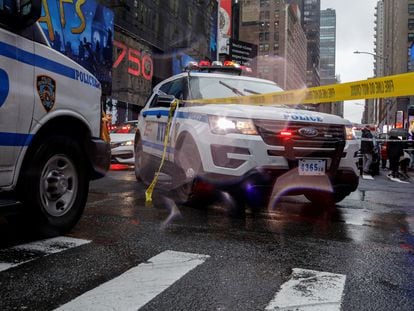Patrol cars from the New York Police Department block a street next to a crime scene.