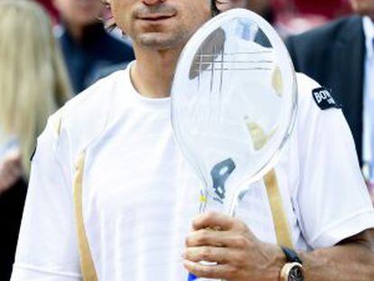 Spain&#039;s David Ferrer holds the trophy after winning the men&#039;s single final against compatriot Nicol&aacute;s Almagro.