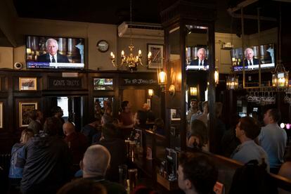 People watch a broadcast of Britain's King Charles III first address to the nation at a pub in London.