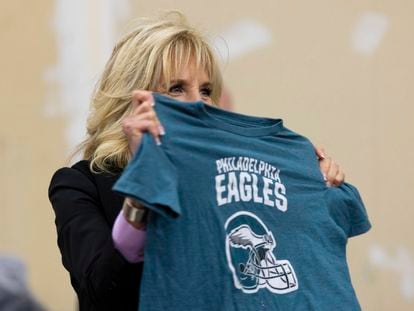 First lady Jill Biden holds up a Philadelphia Eagles shirt while sorting children's clothes at the FEMA State Disaster Recovery Center in Bowling Green, Ky., Jan. 14, 2022.