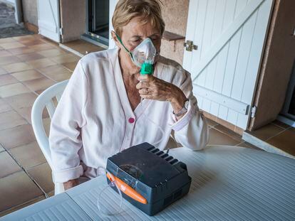 A woman with asthma uses a nebulizer.