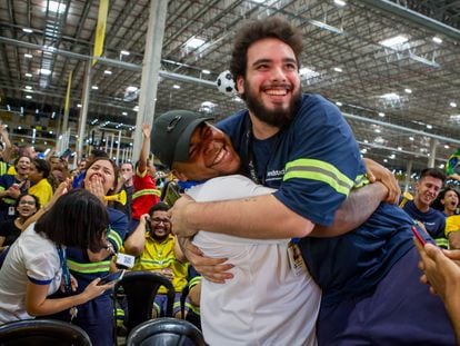 Two men celebrate a Brazil goal at a Mercado Libre distribution center.