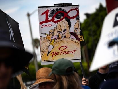 A demonstrator holds a poster reading '100 days 0 retreat' as members of the Writers Guild of America (WGA) protest in front of the Paramount studios in Los Angeles, California, USA, 09 August 2023.
