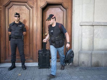 Civil Guard officers walk out of Catdem and Fòrum Barcelona after searching the premises in August.