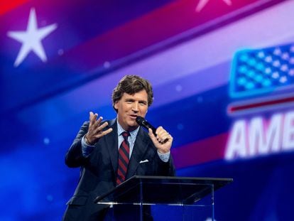 Former Fox News host Tucker Carlson addresses conservative leaders at the AmericaFest forum in Arizona on December 18.