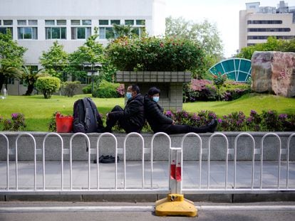 A couple wearing face masks are seen near a hospital parking lot after the lockdown was lifted in Wuhan.