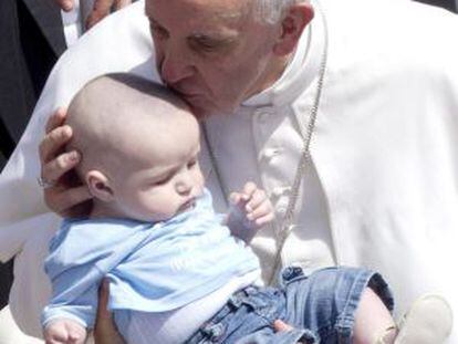 Pope Francis kisses a child at the end of the Canonization Mass in Vatican City on Sunday.