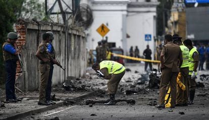 Security officers inspect the area where a bomb exploded in Colombo.