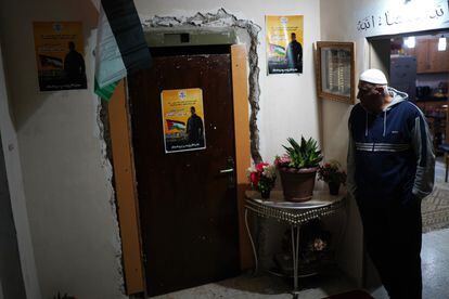 Emad al-Atshan at the door of his home in Ramallah next to posters of his son Omar, a 19-year-old Palestinian prisoner released on Sunday by Israel.